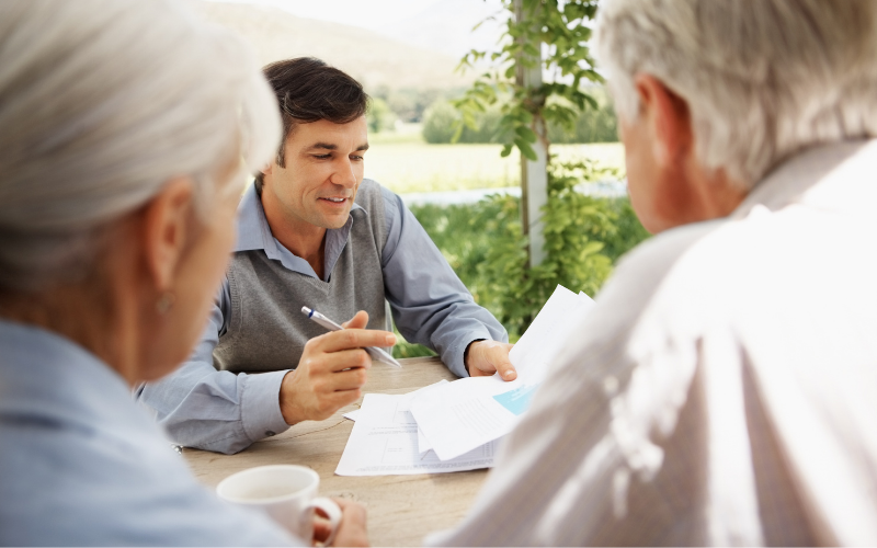 Property broker discussing deal with older couple