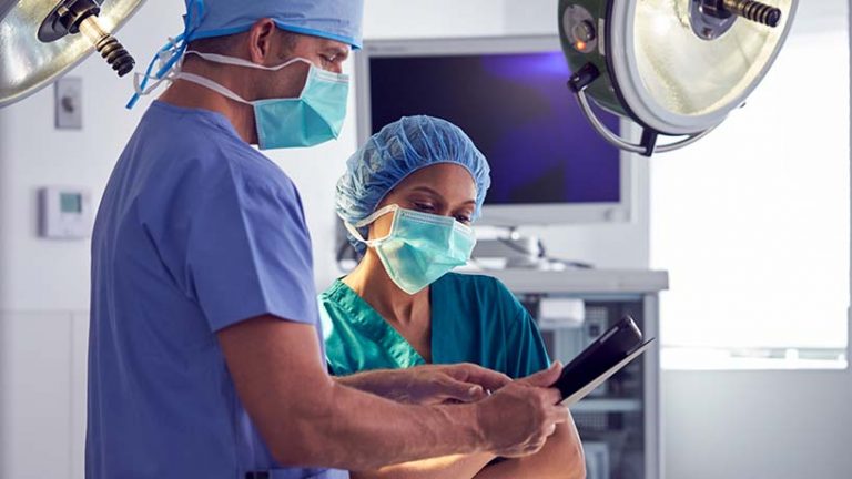 Male and female surgeon looking at ipad