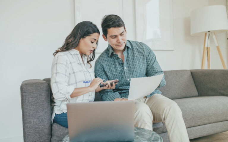 Couple looking at paperwork with laptop