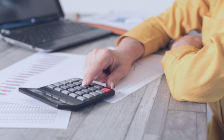 Woman with calculator on desk