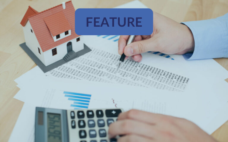 Model home on desk with calculator