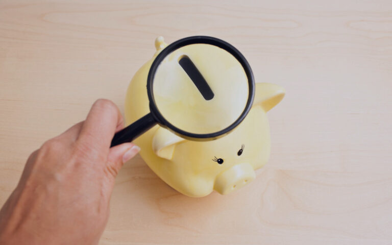Piggy bank with a magnifying glass over it