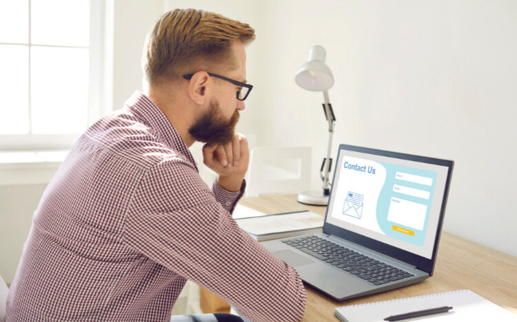 Young professional looking at a laptop with a website profile
