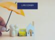 Umbrella over a model family, house and car