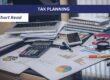 Desk with paperwork, laptop, mobile phone and calculator